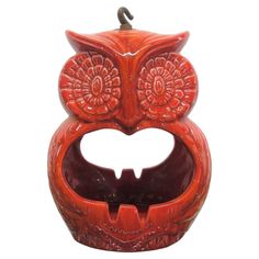 an orange owl shaped candle holder on a white background