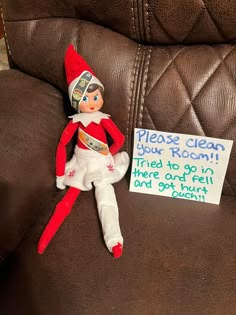 an elf is sitting on the couch with a sign