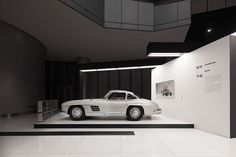 an old white car is on display in a museum