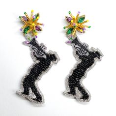 Who brings the music to the Mardi Gras Party? The Jazz Musicians! They are a very important part of the Parades and Carnivals. We were inspired by the Joy they bring to people with their music. These earrings make us want to jazz it up the party! They are very unique and made exclusively for our Gaby & Grace customers. They are handmade with crystals and beads in Mardi Gras colors on the stud, beautiful and delicate hand embroidery on the trumpet and body. These earrings will definitely make Handmade Party Clip-on Earrings, Handmade Party Plug Earrings, Silver Music-themed Jewelry For Party, Music-themed Silver Jewelry For Parties, Mardi Gras Earrings, Mardi Gras Colors, Man Earrings, Mardi Gras Outfits, Bead Dangle Earrings