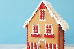 a gingerbread house decorated with icing and candy canes on a blue background