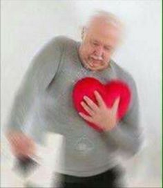 an old man holding a red heart in his hands