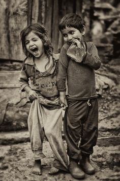 two children standing next to each other with their mouths open