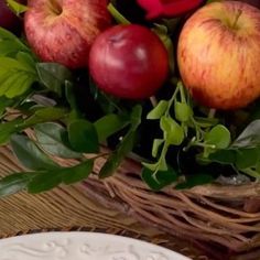 a basket filled with apples sitting on top of a table next to a white plate