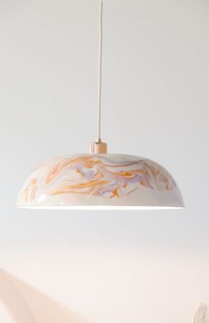 a white and orange lamp hanging from a ceiling