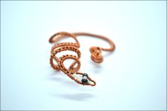 Snake Ear Wrap/No piercing Ear Cuff/Reptile Ear Cuff/Ear wrap/Snake Earring/Wire Wrapped Ear Cuff/Raw Copper Ear Cuff/Boho Ear Cuff/Gift For Her ❤️ Wire wrapped snake ear wrap. No piercing required! It's made of raw copper wires and seed beads and you have the option to choose between the natural copper color or oxidized copper color. The eyes of the snake are dark blue and the rest of the head is light blue seed beeds. Almost any other colors available. Just message me! ★ PLEASE READ THE BELOW: Unique Adjustable Spiral Wrap Earrings, Adjustable Ear Cuff For Pierced Ears As Gift, Adjustable Ear Cuff As A Gift, Wire Wrapped Metal Ear Cuff As Gift, Unique Ear Cuff As Gift With Ear Wire, Unique Wire Wrapped Body Jewelry As Gift, Handmade Adjustable Wrap Earrings, Handmade Unique Copper Ear Cuff, Unique Handmade Copper Ear Cuff