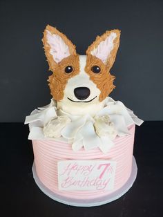 a birthday cake decorated with a dog's face in a pink hat box on a table