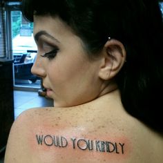 a woman's back with the words would you kindly tattooed on her upper arm