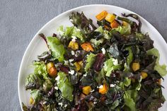 a white plate topped with salad on top of a table