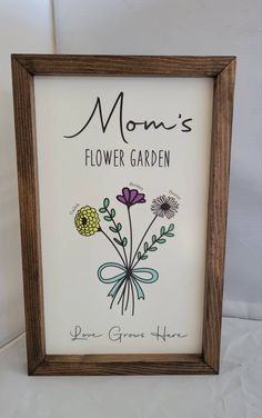 a framed flower garden sign with the words mom's flower garden written on it