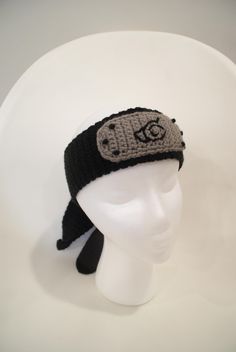 a white mannequin head wearing a black and gray knitted hat