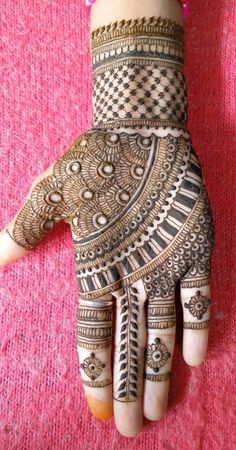 a henna on someone's hand that is decorated with intricate designs and beads