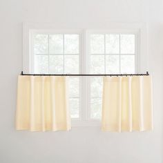 the curtains are hanging in front of the window with white walls and windowsills