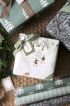 presents wrapped in wrapping paper and tied with ribbon on wicker tablecloth, surrounded by evergreen branches