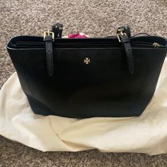 Good Used Condition. Black Purse With Gold Details. Will Come With Dust Bag. Please See All Pics Closely. Rubber Lining To Strap On The Outside Is Missing. Not Noticeable Tory Burch Perry Tote, Tory Burch Robinson Tote, Sport Tote Bag, Tory Burch Ella Tote, Canvas Beach Tote, Ella Tote, Tory Burch Tote, Tory Burch Bag Totes, Straw Tote Bag