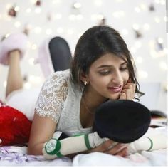 a woman laying on top of a bed next to a stuffed animal