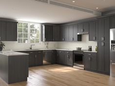 an empty kitchen with stainless steel appliances and wood floors