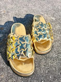 Gold star standard isn't just a saying--it's a real life pair of comfy slides! Our Born Star slides are great with your favorite summer staples or with a pair of jeans in the early fall. Whenever you choose to wear them, you're sure to be the main attraction!   * These slides run small. Order a size up. * Genuine leather  * Molded footbed * Hand placed star embellishments * Comfortable, padded insole * Rubber outsole * There may be differences in color due to variances in monitor displays Casual Gold Slides For Vacation, Trendy Gold Slides For The Beach, Gold Casual Slide Sandals, Casual Gold Slide Sandals, Gold Casual Slip-on Slides, Trendy Gold Open Toe Slides, Casual Gold Slides For Spring, Comfy Slides, Birkenstock Style