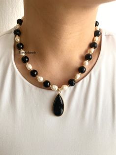 ✨Gold-Plated Black Agate and Freshwater Pearl Necklace | Black and White Elegant Necklace Enhance your jewelry collection with this stunning **Gold-Plated Necklace featuring the timeless contrast of **Black Agate** and **Freshwater Pearls**. This handcrafted necklace is a perfect accessory for both casual and formal occasions, adding a touch of elegance and sophistication to your style. ✨ **High-Quality Materials Made with durable gold-plated chains, this necklace combines the sleek look of **Black Agate** with the classic beauty of **Freshwater Pearls**. The gold plating ensures long-lasting shine and a luxurious appearance. 🖤 **Centerpiece The necklace is completed with a **Black Agate Pendant adding a bold and modern touch to the overall design. The agate's natural beauty complements t Elegant Black Beaded Necklaces With Stones, Gift Black Natural Stone Necklaces, Black Beaded Necklaces With Pearl Pendant, Black Beaded Necklace With Pearl Pendant, Black Gemstone Necklaces With Round Beads, Elegant Onyx Crystal Necklaces With Natural Stones, Elegant Black Crystal Necklace With Gemstone Beads, Black Agate Beaded Necklace With Gemstones, Black Pearl Necklace With Round Bead Pendant