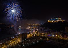 fireworks are lit up in the night sky above a city