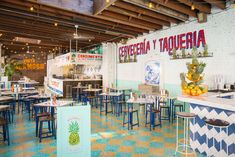 the inside of a restaurant with blue and yellow tables, stools and counter tops