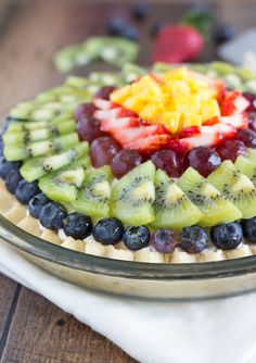 a fruit tart with kiwis, blueberries and strawberries on top