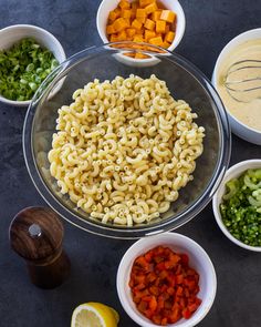 several bowls filled with different types of pasta and veggies next to each other