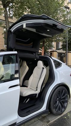 a white car with its doors open on the street