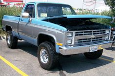 an older pickup truck parked in a parking lot