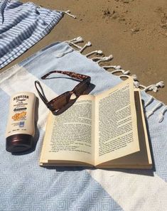 an open book and sunglasses on a blanket