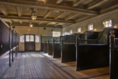 an old building with several stalls and doors in it's center area, all lined up against the wall