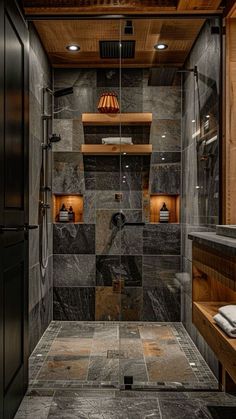 a walk in shower sitting next to a wooden shelf filled with towels and other items