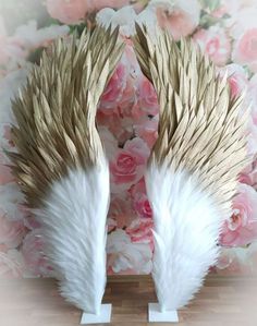 two white angel wings on top of pink flowers