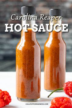 two bottles filled with sauce next to some red peppers