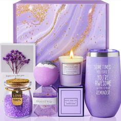 a purple candle and some other items on a white surface with gold flecks