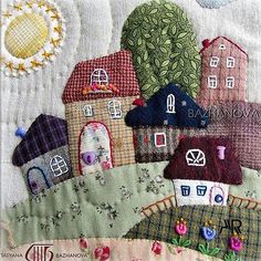 a close up of a quilt with houses on it