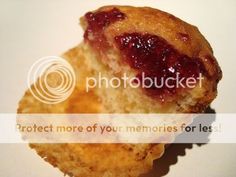 a muffin with jam on it sitting on top of a table