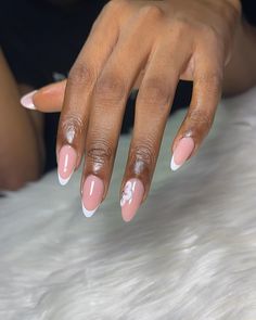 a woman with pink and white french manies on her nails, sitting in front of a fur rug