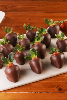 chocolate covered strawberries are arranged on a white platter