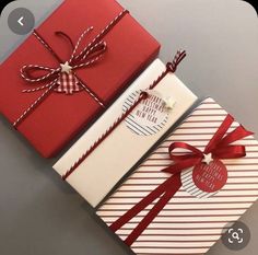 two red and white boxes with bows on them, one has a tag attached to it