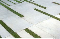 a man riding a skateboard down the side of a cement walkway next to grass