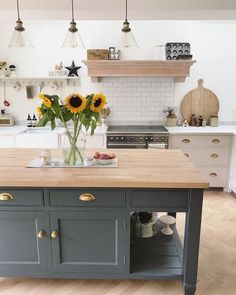 a kitchen island with sunflowers on it in the middle of a wooden floor