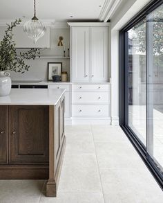 a large kitchen with white cabinets and marble counter tops, along with an island in the middle