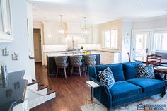 a living room filled with furniture next to a kitchen and dining room table on top of a hard wood floor