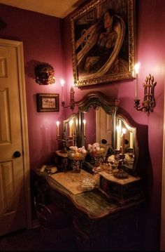 a vanity with two candles on it in front of a painting