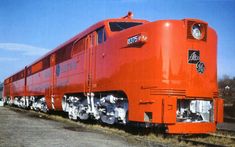 an orange train engine sitting on the tracks