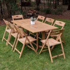 a wooden table and chairs in the grass