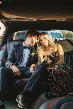 a man and woman sitting in the back of a car