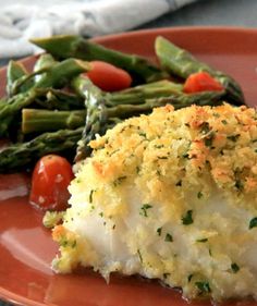 a red plate topped with fish and veggies