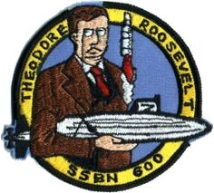 a patch with a man holding a large object in his right hand and the words theodore roosevelt ssn 600 on it